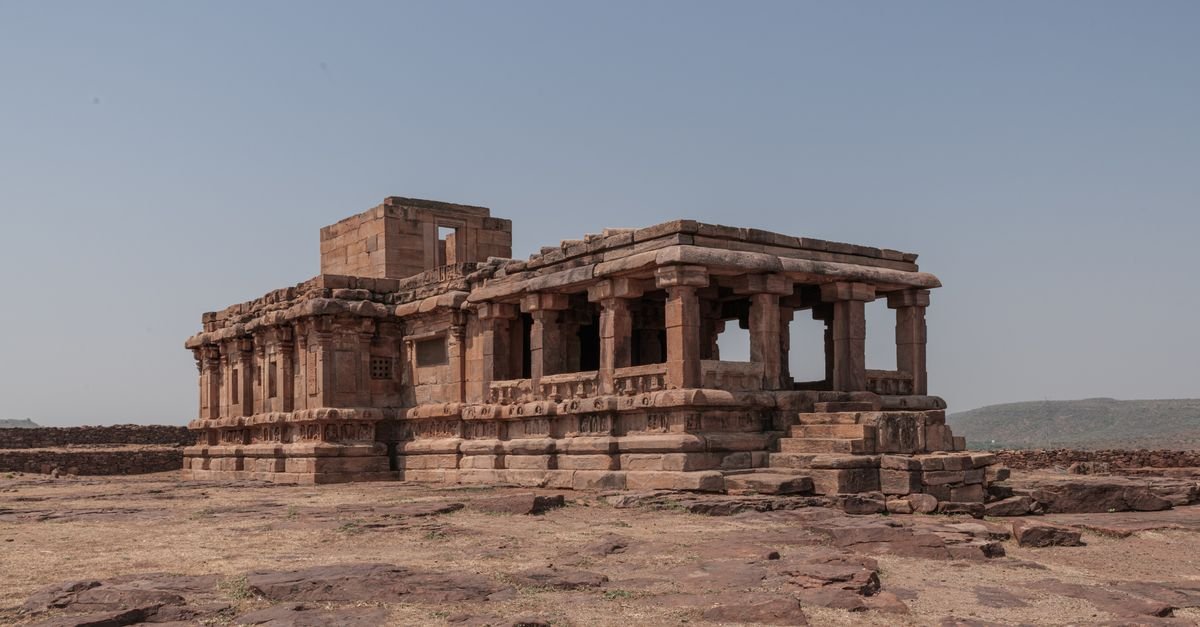Explore the ancient temple ruins in Aihole, Karnataka, showcasing historic architecture under a clear sky.