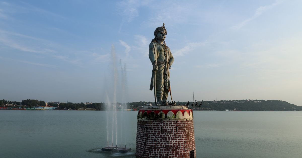 Raja Bhoj statue in Bhopal, India, standing tall in a serene lake view.