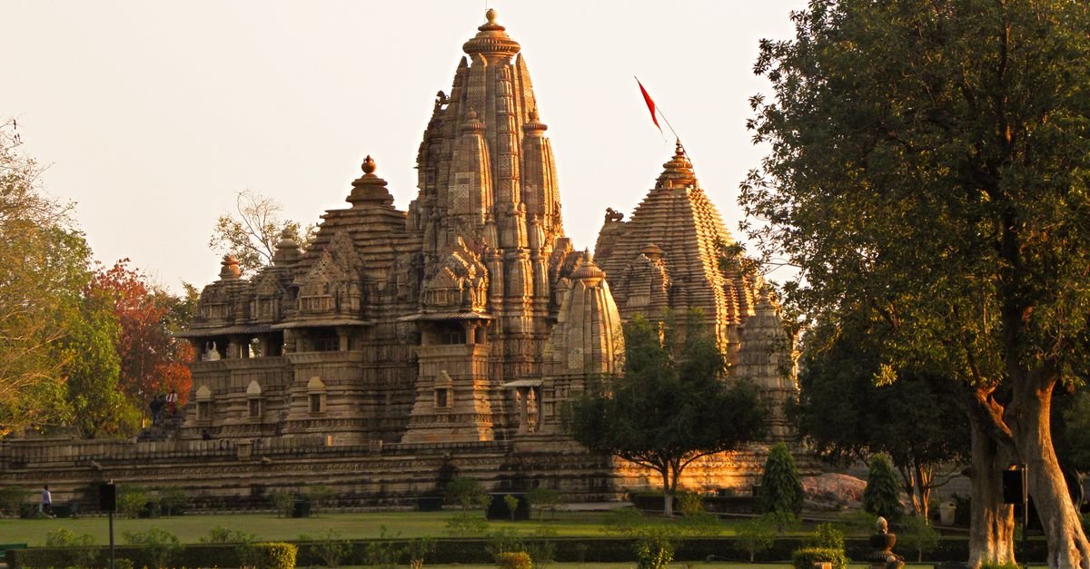 View of the historic Khajuraho Temples in Madhya Pradesh during sunset, highlighting ancient architecture.